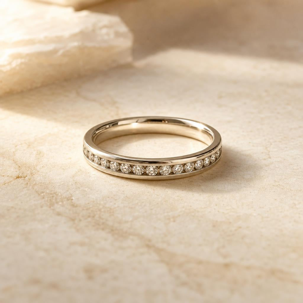 Sleek ring with stones set flush in a metal channel on cream stone
