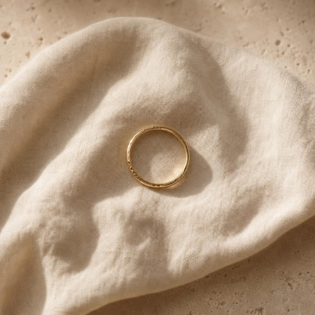 Delicate ring resting on warm cream linen with soft natural light