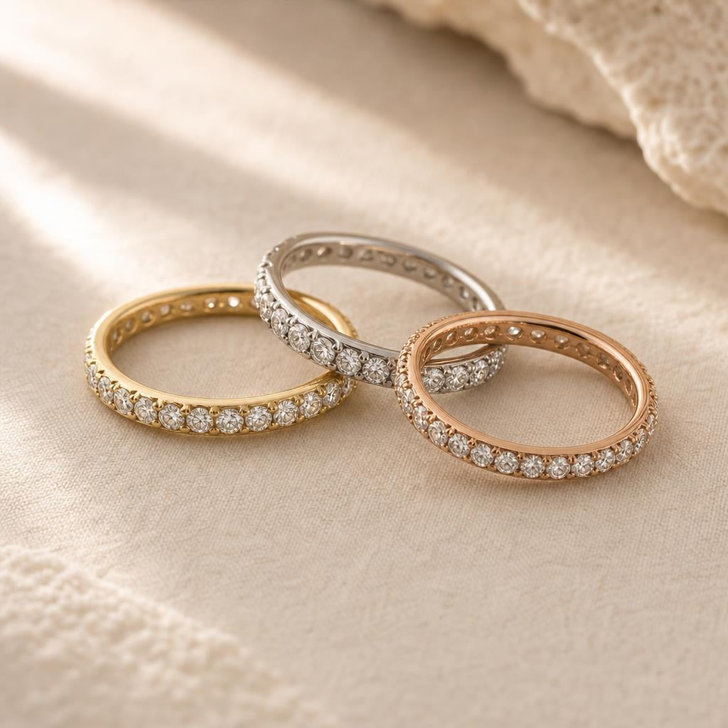 Three slim diamond eternity band rings overlapping on warm cream linen