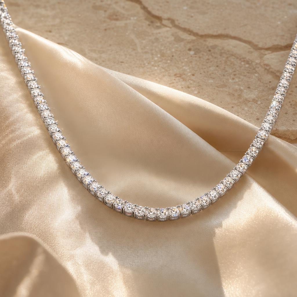 Moissanite tennis necklace laid in a soft curve on cream silk