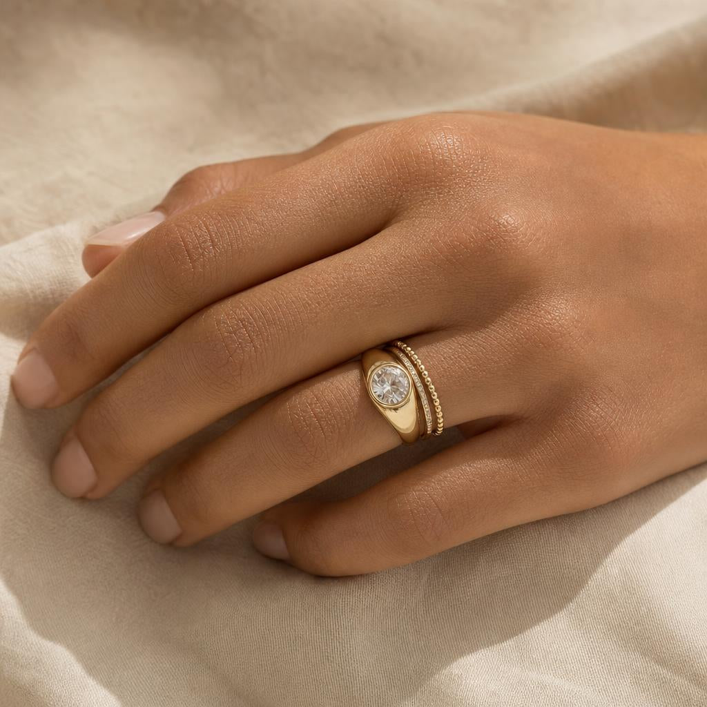 Hand wearing a stacked ring set with a bold centerpiece