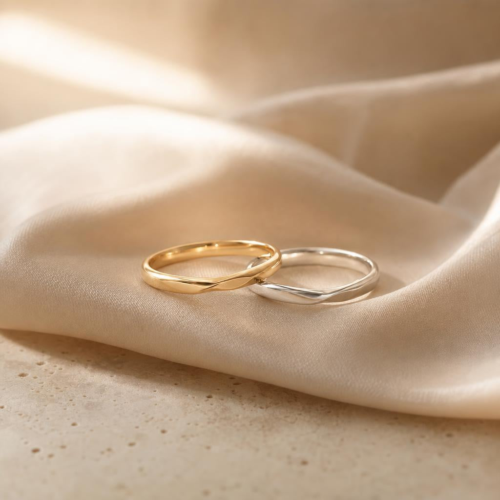 Two slender minimalist rings paired together on warm cream fabric