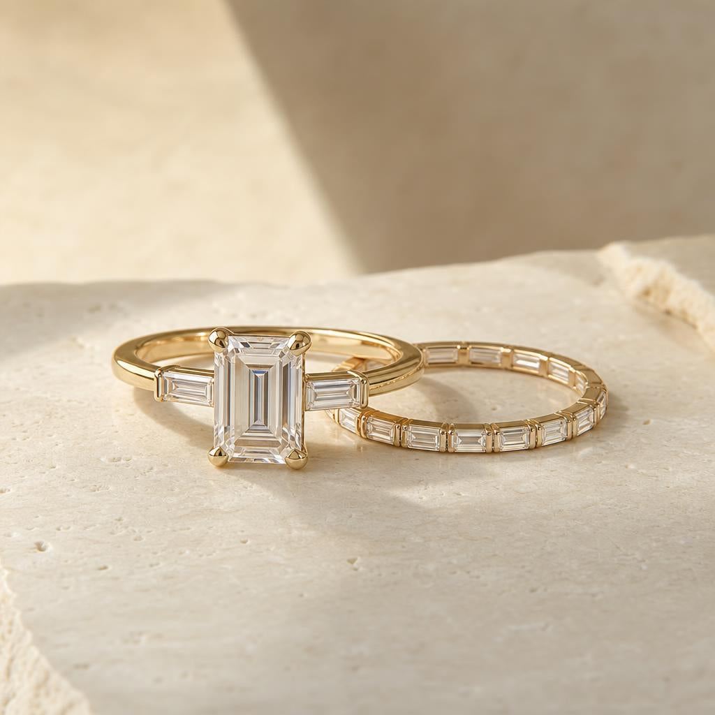 Emerald cut simulated diamond ring paired with slim baguette eternity band on cream stone