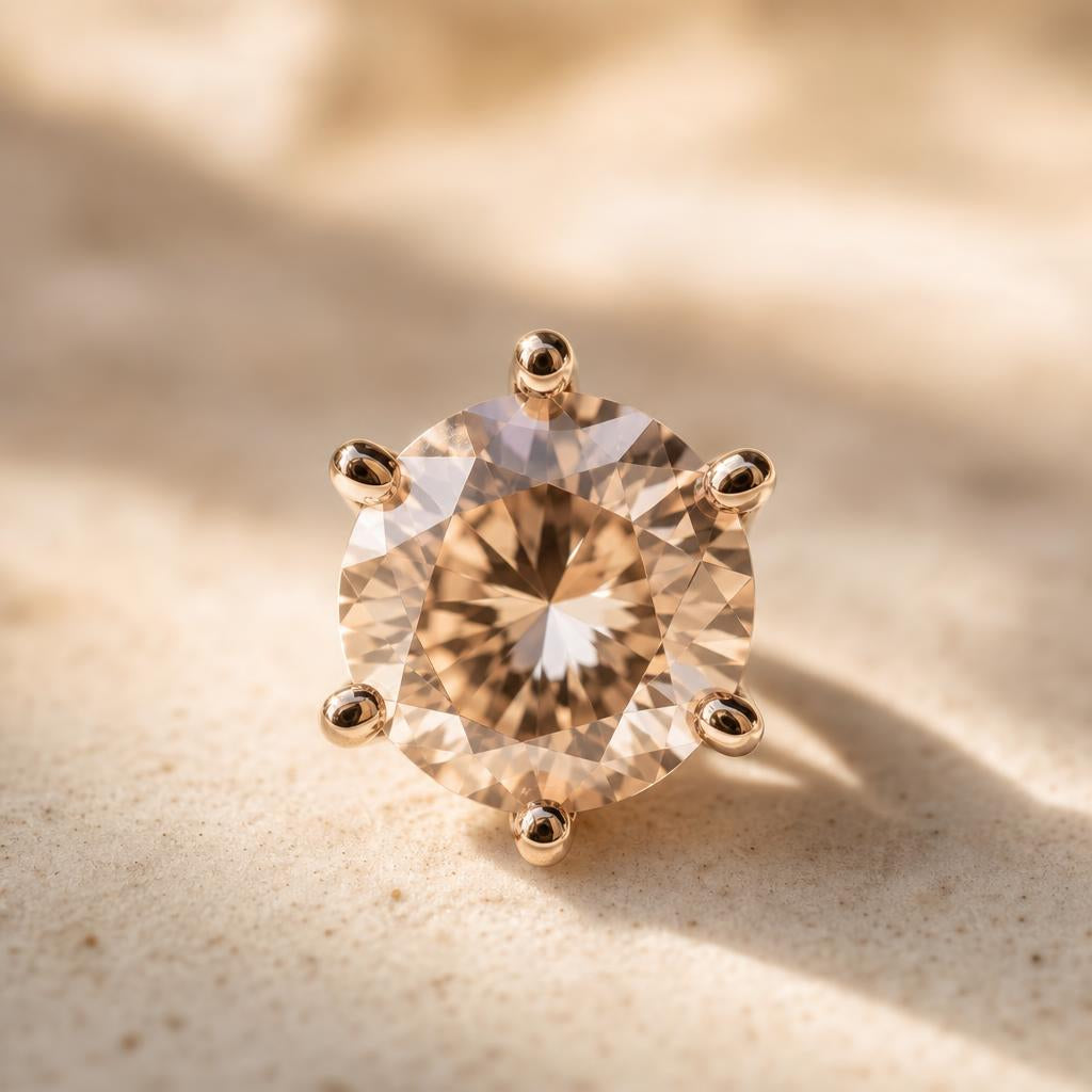 Close-up of a faceted gemstone held by metal prongs on cream background