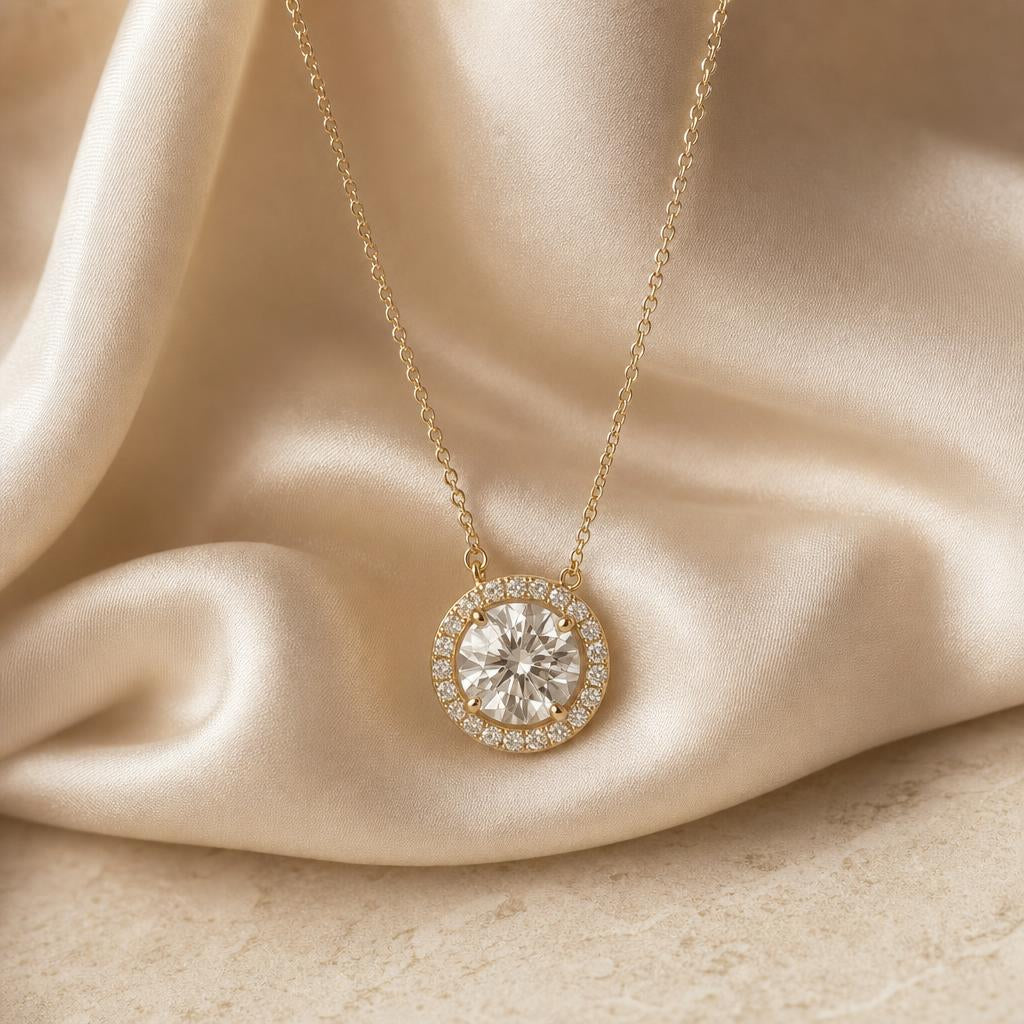 Halo-set pendant necklace resting on warm cream silk fabric