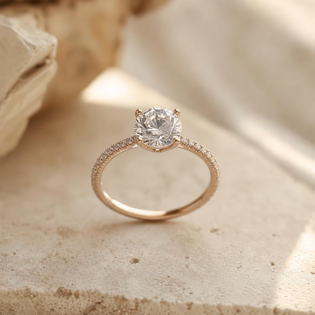 Close-up of a sparkling solitaire ring with pavé band on cream background