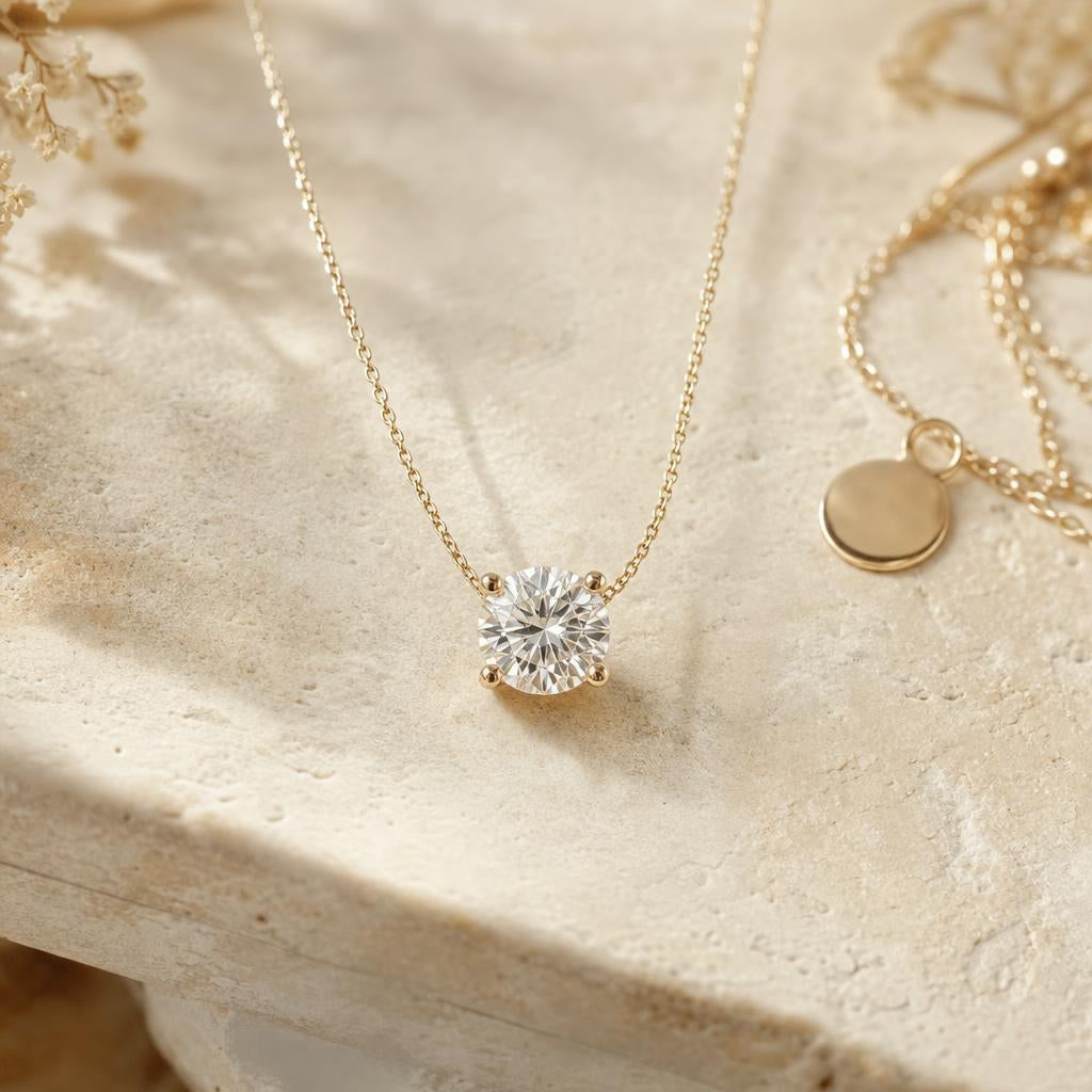 Delicate round gemstone pendant necklace resting on warm cream stone surface