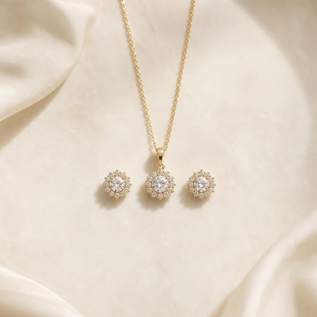 Coordinated pendant necklace and stud earrings arranged on warm cream silk