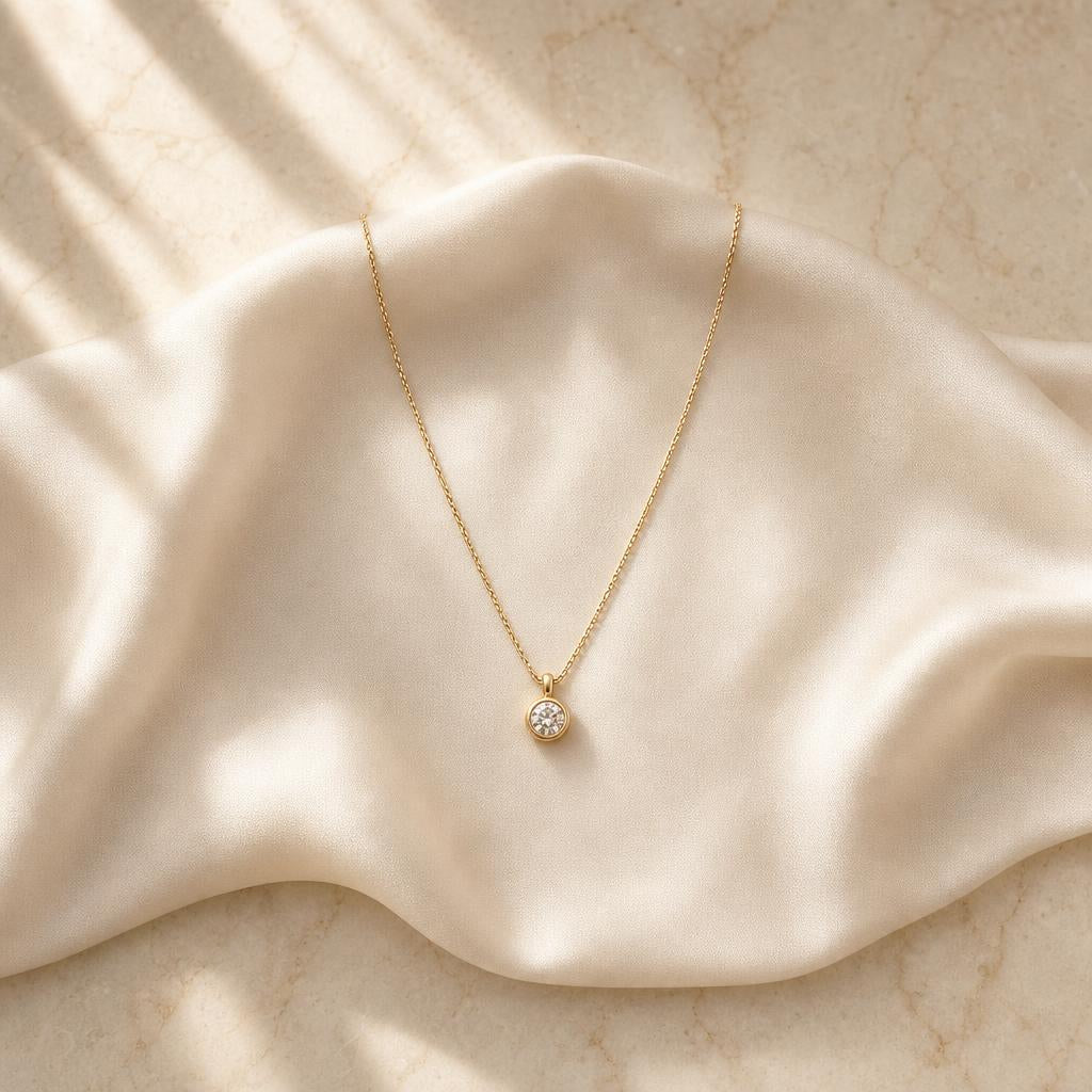 Delicate pendant necklace on ivory silk, quiet old money aesthetic