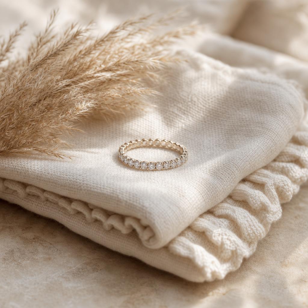 Sparkling eternity ring resting on a cream linen baby blanket