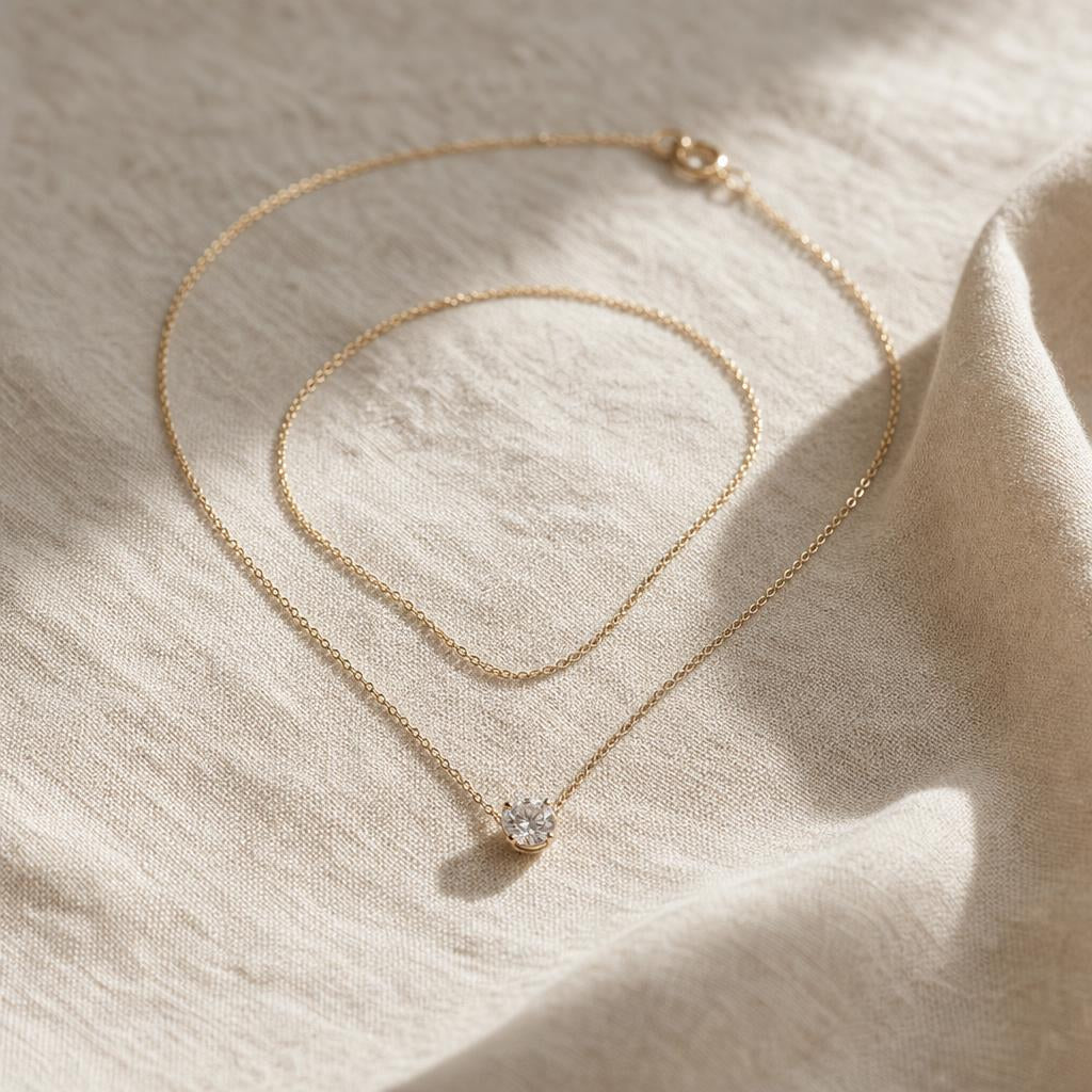 Delicate minimalist necklace coiled on warm cream linen with soft natural light