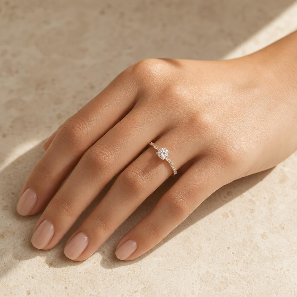 Elegant hand wearing a sparkling ring resting on warm cream stone