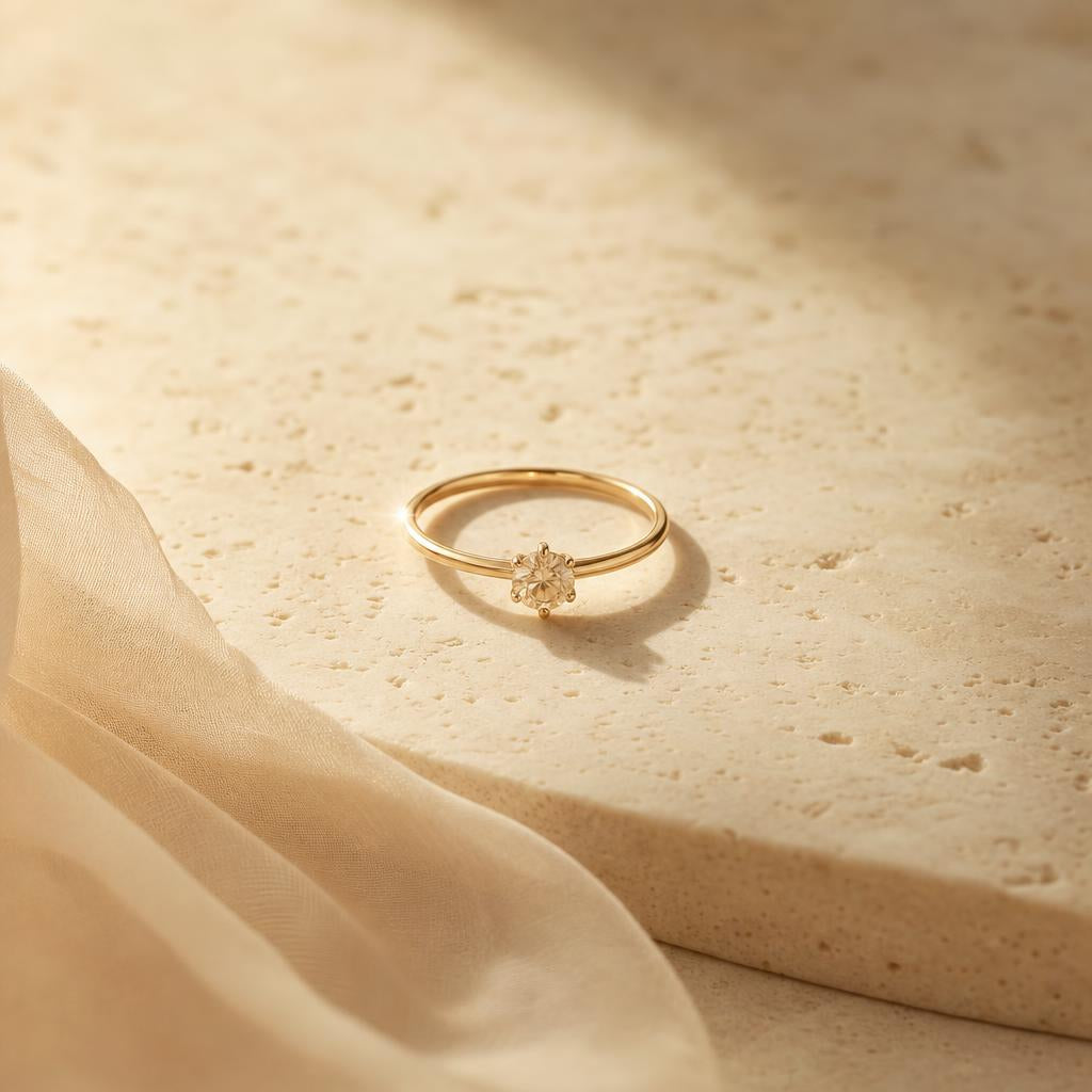 Delicate ring resting on warm cream stone with soft natural light
