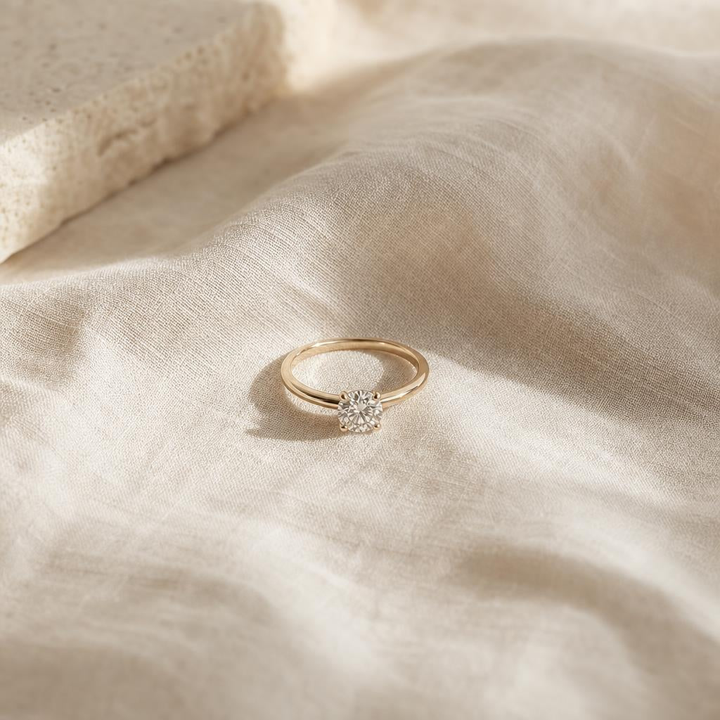 Single minimalist solitaire engagement ring on soft cream linen