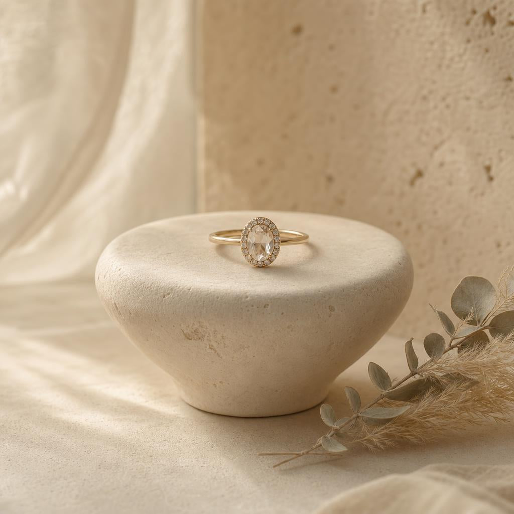 Simulated diamond ring resting on a cream stone pedestal with dried grass