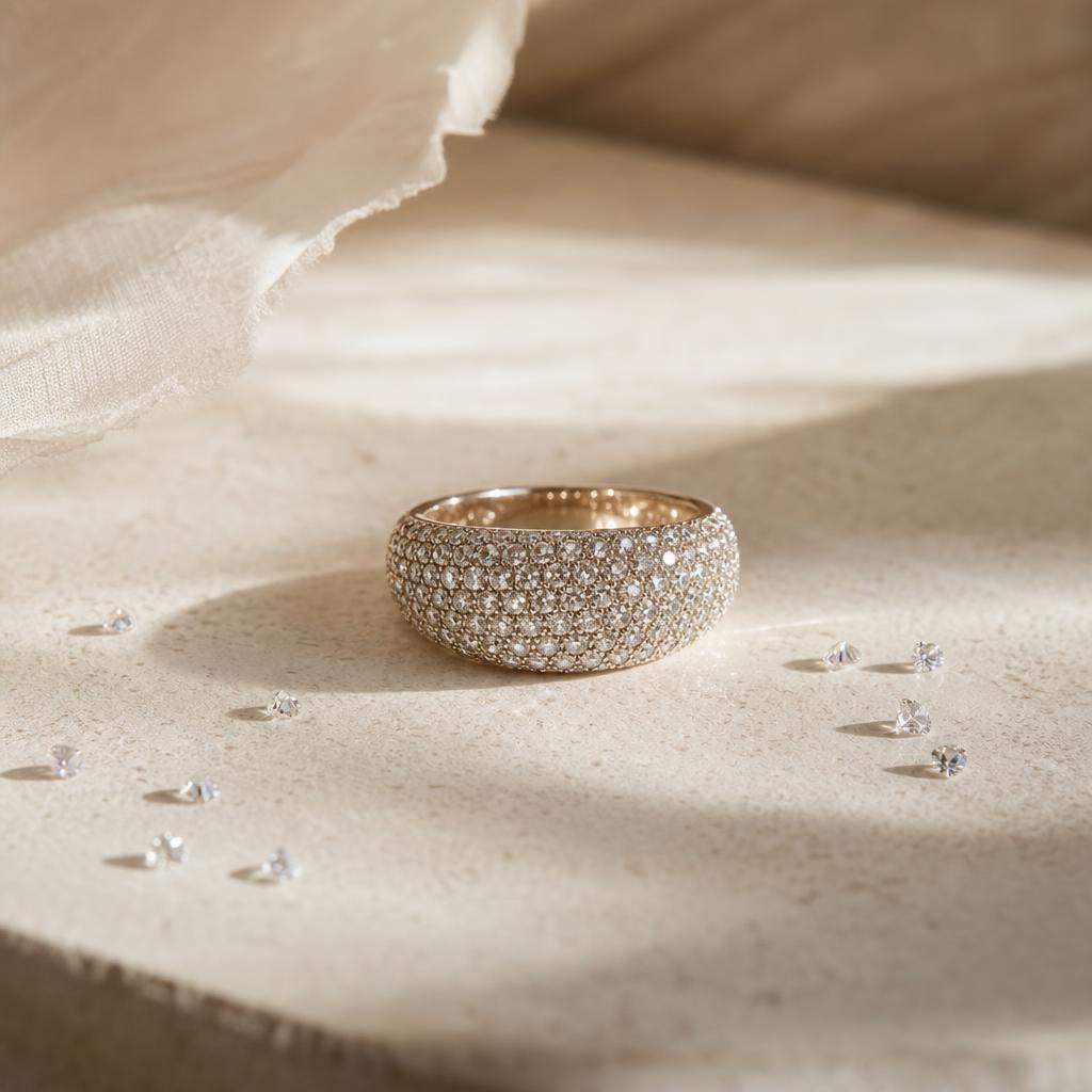 Close-up of a sparkling pavé-set ring on a warm neutral background