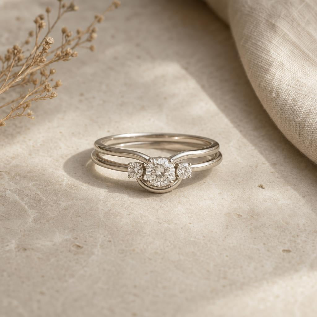 Three delicate stacked rings with contoured bands on a warm stone surface