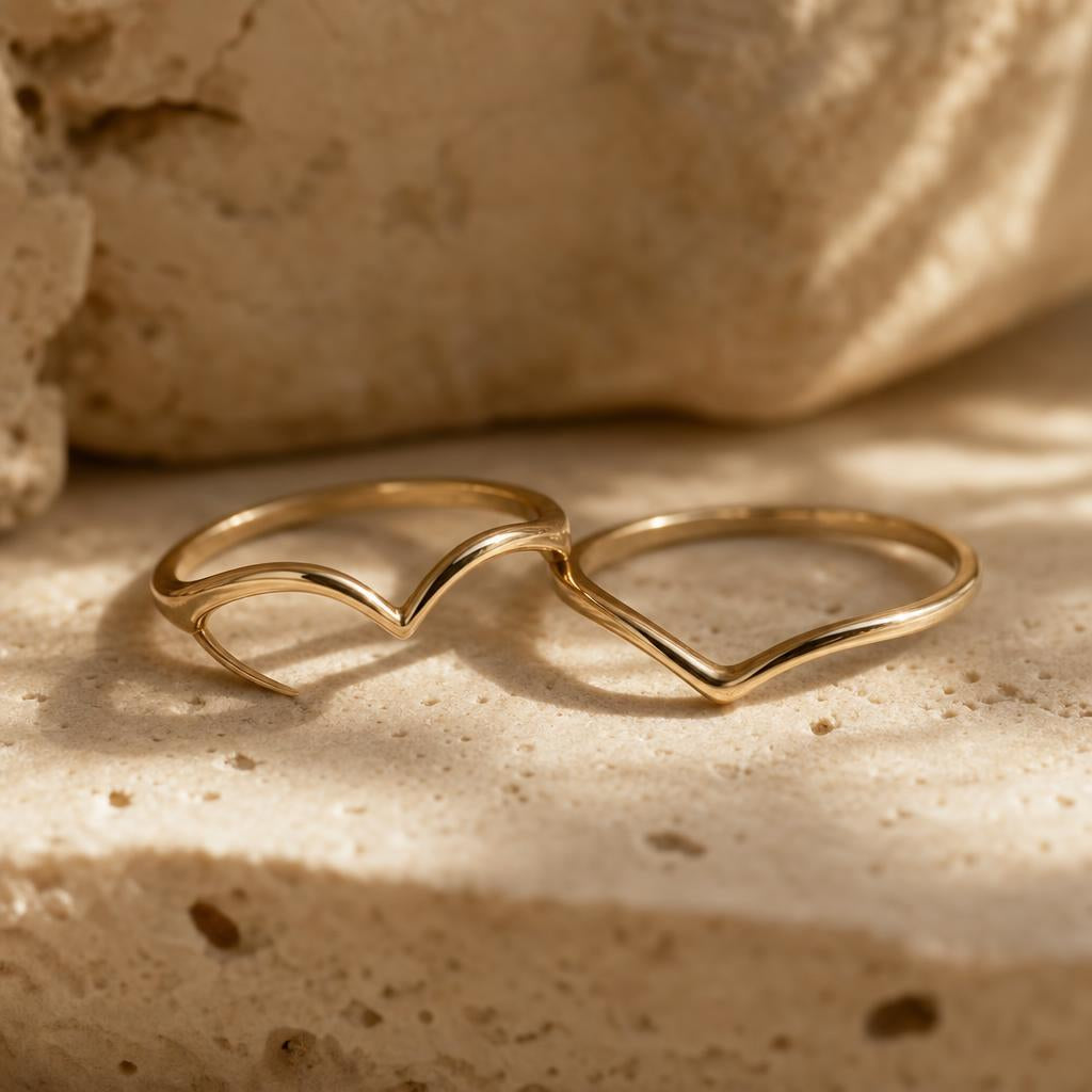 Heart-shaped ring paired with a curved metal wedding band on stone