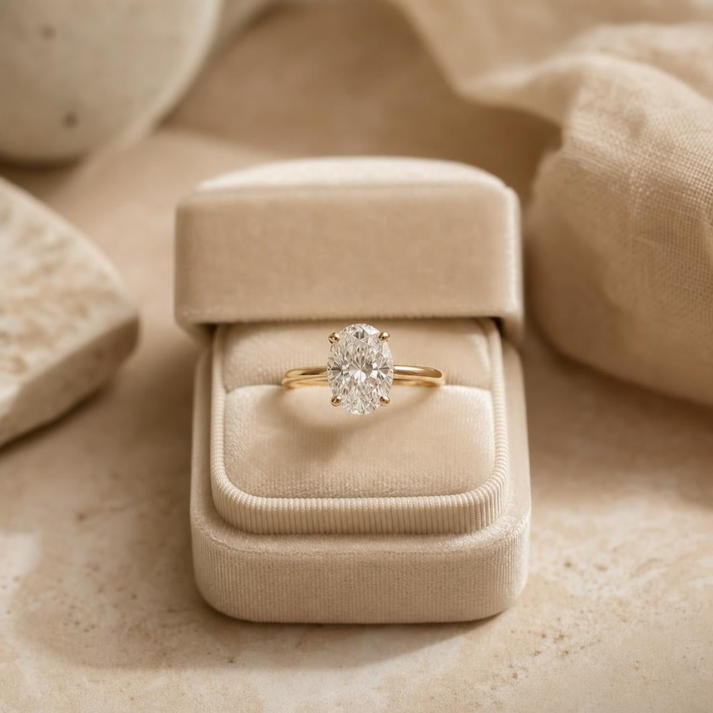 Engagement ring resting in an open cream velvet ring box